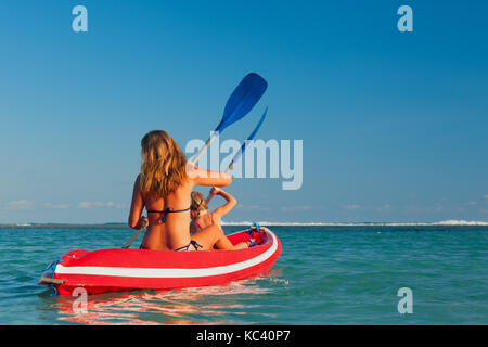 Familia feliz - madre, hija divertirse en barco Paseo. mujer, niño remar en kayak. Viajes de estilo de vida, los padres con niños actividad recreativa
