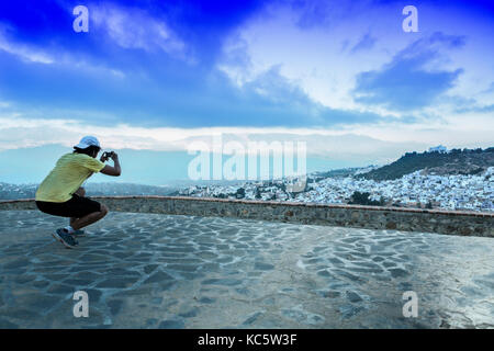 Deportista observar una vista panorámica de la ciudad azul de Chefchaouen, Marruecos en el Rising Foto de stock