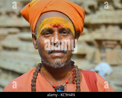 Sadhu Shaivite de mediana edad con turbante naranja, marca de tilaka roja y pasta de sándalo amarillo en su frente, cuentas de rudraksha alrededor de su cuello Foto de stock