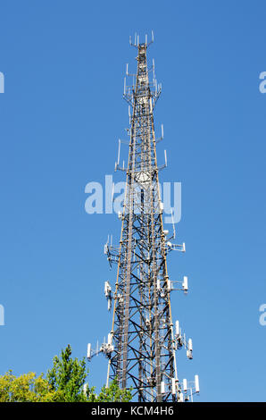 Torre de comunicaciones celulares con antenas múltiples contra el cielo azul claro. Ee.Uu. Foto de stock