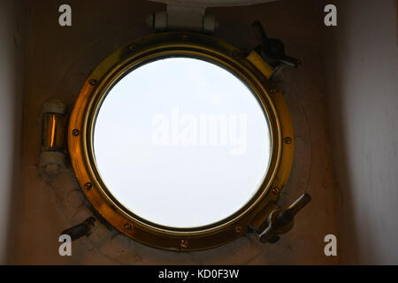 Ojo de buey de oro desde el interior en un barco Foto de stock