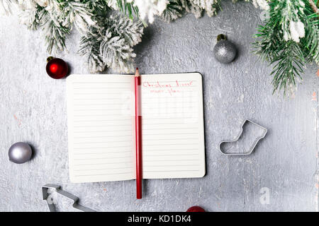 Menú navideño plan. fondo para escribir el menú navideño. vista desde arriba. cuaderno sobre fondo gris con decoración