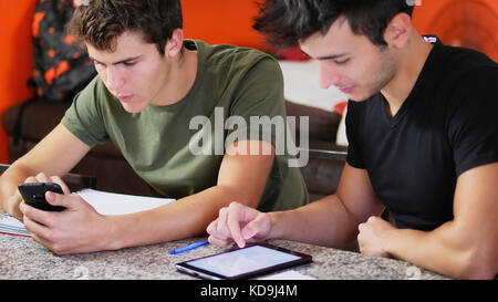 Los jóvenes estudiantes que estudian con los gadgets Foto de stock