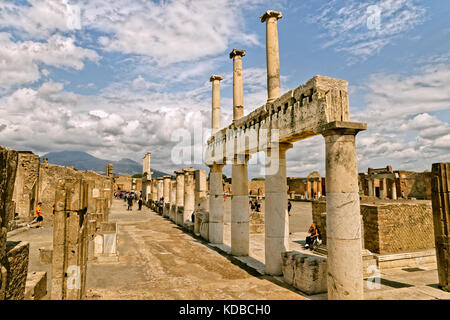 Arcadian camino con columnas dóricas en el Foro en las ruinas de la ciudad romana de Pompeya Scavi en Pompeya, cerca de Nápoles, Italia. Monte Vesubio en la distancia.