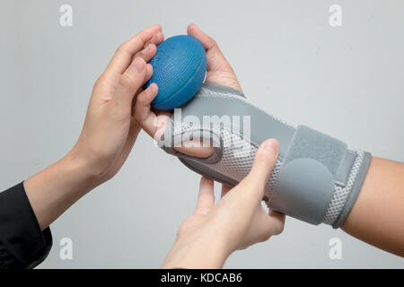 Mano de mujer con apoyo muñeca apretar una pelota suave para ejercer mano , mano de rehabilitación Fotografía de stock - Alamy