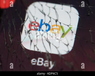 El logotipo de ebay sobre una fisura en la pantalla del smartphone Foto de stock