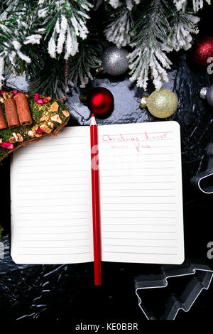 Menú navideño plan. fondo para escribir el menú navideño. vista desde arriba. cuaderno sobre fondo negro con decoración
