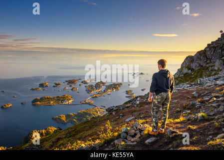 Excursionista de pie en la cima del monte festvagtinden en las islas Lofoten en Noruega Foto de stock