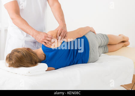 Close-up de masajistas haciendo masajes en el brazo de la mujer en spa Foto de stock