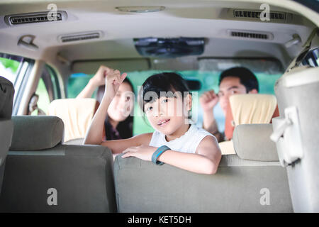 Niña feliz con la familia de Asia sentado en el coche para disfrutar del viaje y vacaciones de verano en autocaravana