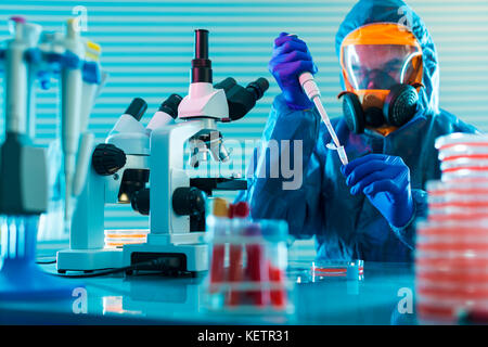 La investigación del peligroso virus en el laboratorio. La prevención de una pandemia. un científico en un traje de protección biológica trabaja con una pipeta