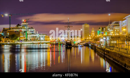 Dublín, Irlanda, vista de noche de Samuel Beckett Bridge a Jeanie Johnston Tall Ship, contra el telón de fondo de la Sean O'Casey Puente sobre el río Lif