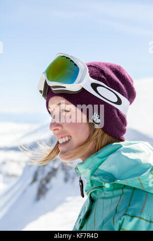 California, Estados Unidos, Mammoth, una hembra snowboarder sonríe y ríe mientras toma un descanso en un plazo al resort de esquí Mammoth Foto de stock