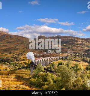 Viaducto de Glenfinnan y el tren de vapor jacobita sopla el vapor de escape como se cruza el Viaducto de Glenfinnan, Highland, Escocia, Reino Unido. Foto de stock