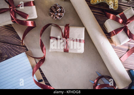 Vista superior decoraciones navideñas y regalos empaquetados, portátil en madera rústica, mesa plana estilo laical. concepto de planificación de navidad. El enfoque selectivo. Espacio f