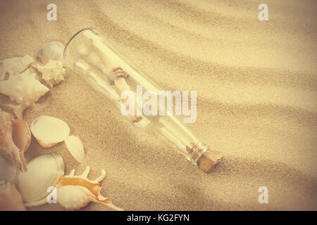 Mensaje en una botella en la playa. verano caliente con fondo de arena, en estilo vintage