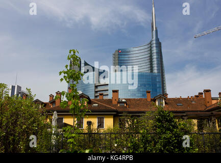 Milán, Italia - 10 de mayo de 2014: Milan entre historia y modernidad. tradicional histórica casa milanesa en primer plano con la nueva y moderna construcción de vidrio
