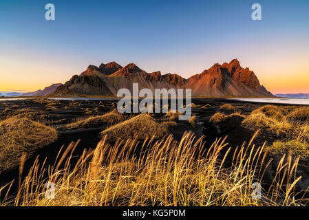 Stokksnes, hofn, este de Islandia, Islandia. vestrahorn mountain y las dunas de arena negra al atardecer. Foto de stock