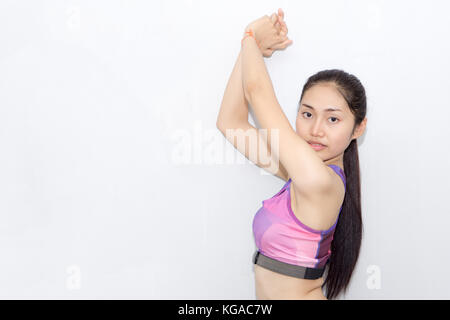 Mujer joven en el sujetador deportivo y monitor de ritmo cardíaco con cinta aislado en blanco Foto de stock