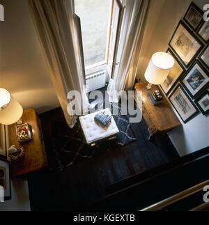 Vista desde arriba de una sala de estar en un elegante apartamento en Italia con dos tocadores y una bolsa
