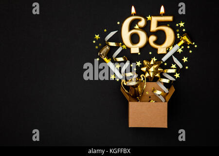 Celebración de oro número 65 velas y fondo de caja de regalo Foto de stock