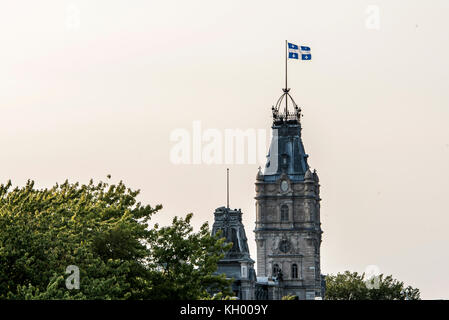 La ciudad de Quebec Canadá la bandera azul y blanca ondea orgullosamente en la parte superior de la impresionante torre del reloj del edificio del parlamento de la asamblea nacional Foto de stock