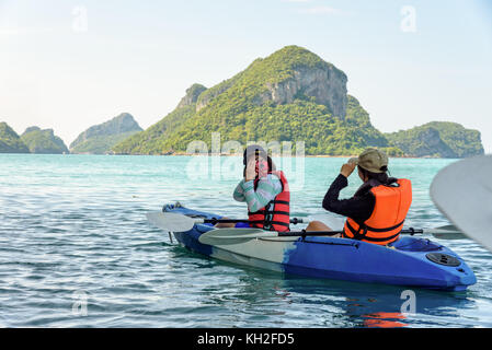 Dos mujeres son madre e hija utilizando una cámara toma fotografías en kayak mientras viaja en barco con happy en el mar durante el verano en ko Wua Ta Lap isla