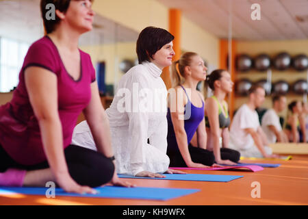 Mujer 40s metida en yoga en el gimnasio estilo de vida activo.