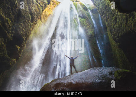 Viajar a Islandia, persona con manos levantadas en pie en cascada, inspirado Gljufrabui viajero feliz disfrutando la naturaleza, concepto de aventura