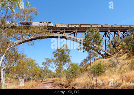 Tren de mineral de hierro más grande cruzando la propiedad privada solo span en un puente ferroviario en el hemisferio sur, Pilbara, Australia Occidental Foto de stock