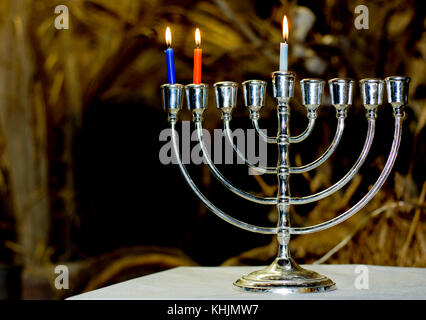 Un chanukia el principal símbolo de Hanukkah, el judío, el festival de la luz con 3 velas para el segundo día Foto de stock