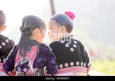 Encantador chico y chica jugar afuera mientras posan vistiendo ropa étnica de la tribu Hmong, pueblo indígena de Tailandia.