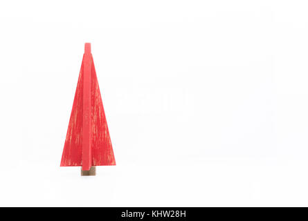 Una estilizada de madera de árbol de Navidad roja con fin apenado contra un fondo blanco. La decoración es a la izquierda y la imagen se copia el espacio. Foto de stock