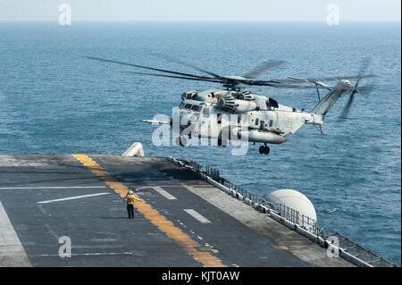 Un cuerpo de marines de EE.UU del tipo CH-53E Super stallion helicóptero aterriza en la cubierta de vuelo a bordo de la marina de los Estados Unidos América clase de buque de asalto anfibio uss america el 20 de noviembre de 2017 en el Golfo Arábigo. (Foto por mano a través de Vance planetpix) Foto de stock
