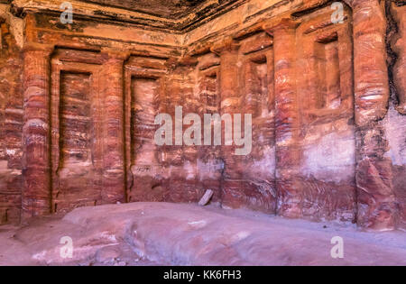 Vista interior de la piedra arenisca rosa y rojo ondulado patrones y columnas dentro del jardín triclinium o salón de banquetes, Petra, Jordania, Oriente Medio