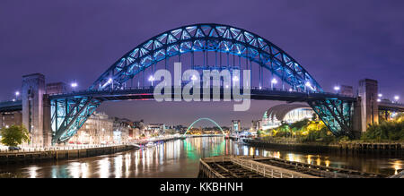 Foto nocturna mirando a lo largo del río Tyne hacia el puente Tyne y el puente Gateshead Millennium, Newcastle upon Tyne, Tyne y Wear, Inglaterra