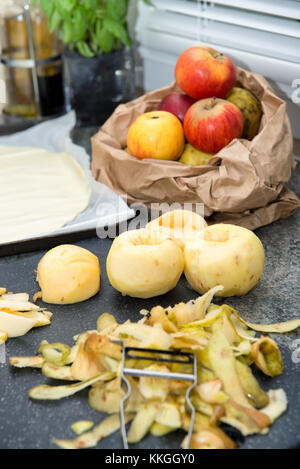 Manzanas peladas y masa para una tarta de manzana Foto de stock