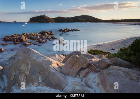 Atardecer en la playa de Porto Giunco arrecife y la antigua torre, Villasimius, Cagliari, Cerdeña, Italia, Europa.