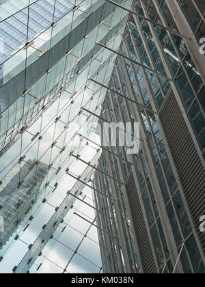 Una perspectiva inclinada de patrones geométricos abstractos de la arquitectura moderna se refleja en el vidrio.