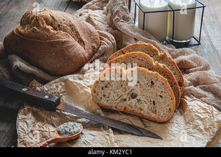 Una hermosa hogaza de pan de masa fermentada de trigo blanco en una placa en un borde de lino. Pasteles caseros.