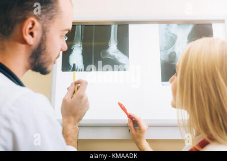 Dos jóvenes médicos mirando a rayos X, medicina y salud concepto de radiología Foto de stock