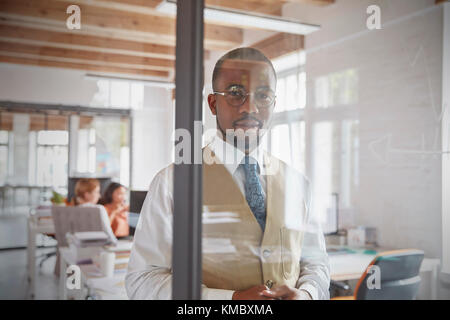 Retrato empresario confía en la ventana en la oficina