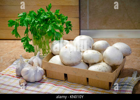 Preparación de "funghi trifolati' (en rodajas finas champignons cocinados con aceite, ajo y perejil) Foto de stock
