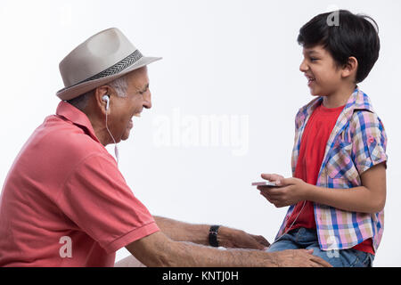 Abuelo y nieto escuchando música Foto de stock