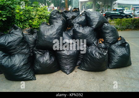 Cierre de bolsas de basura llenas de basura después de limpiar el