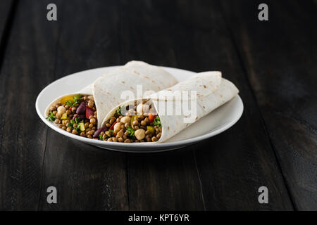 Vegan envuelve con lentejas, garbanzos, porotos, ajíes y humus salsa Foto de stock