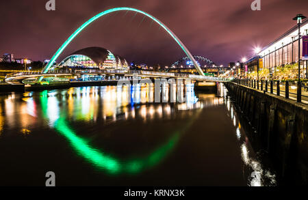 Noche foto mirando a lo largo del río Tyne hacia el Puente del milenio de Gateshead con Tyne Bridge en el fondo, Newcastle upon Tyne, Inglaterra