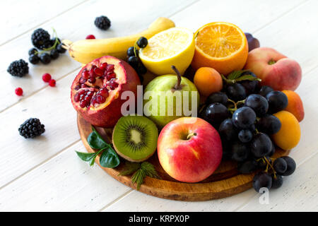 El concepto de una dieta saludable. Plato de frutas y bayas, naranja, pera, manzana, pomelo, uva, melocotón, albaricoque, moras y grosellas. Vegan Foto de stock