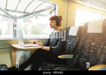 Mujer usando el portátil en el tren