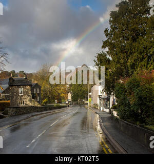 Un arco iris sobre la A591 carretera principal a través de Ambleside, ciudad en Inglaterra del Lake District National Park. Foto de stock
